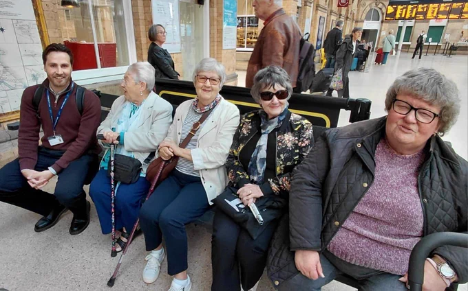 Rob from TransPennine Express and four members are waiting in the Accessible Seating area of York train station.