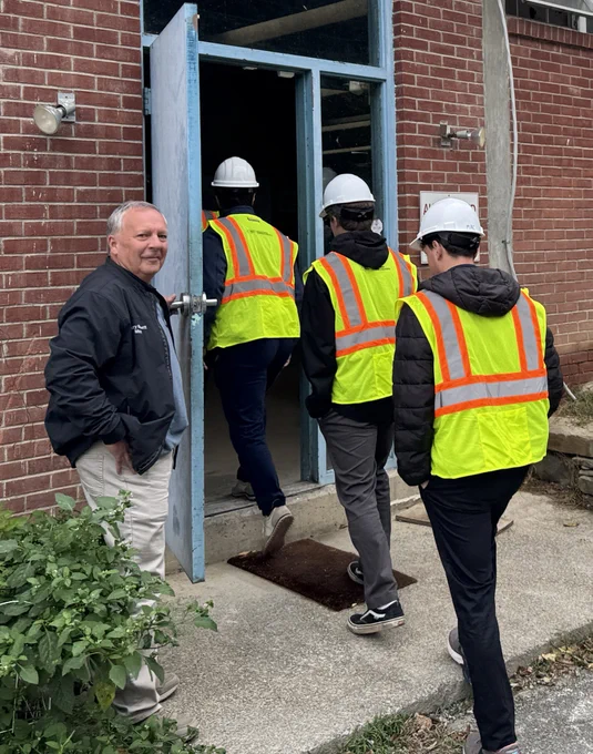 village mayor opens the door to a water treatment facility as EFC staff enter