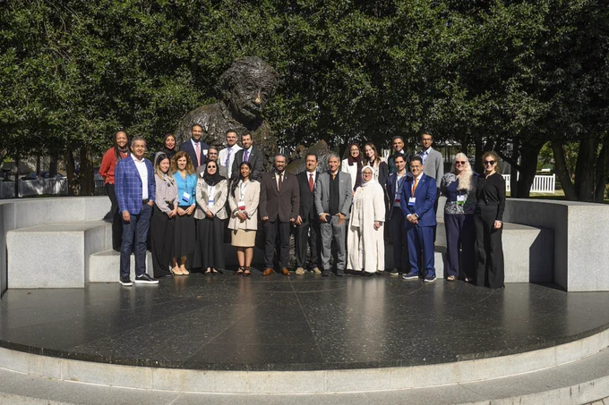 Attendees pose for a photo in front of the Albert Einstein statue outside of the National Academy of Sciences. 