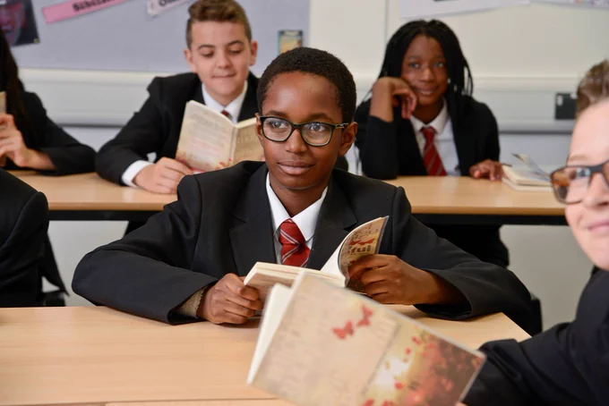 Wilsthorpe School student reading a book in a lesson. 