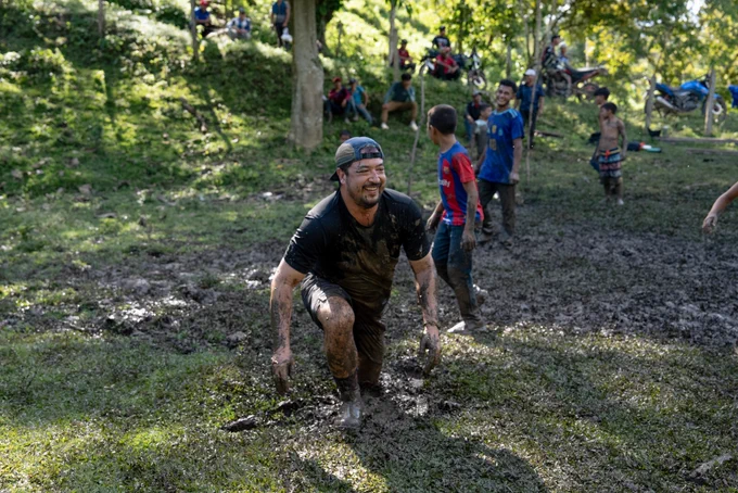 A Trekker named Joseph playing soccer with children in the mud.