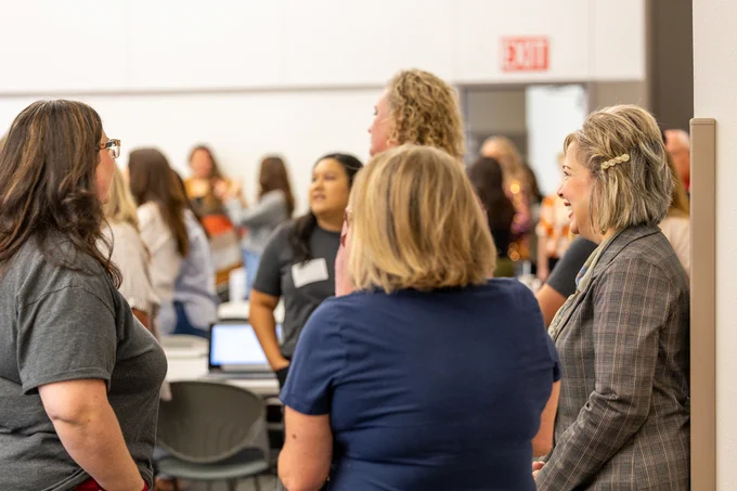 A group of attendees is interacting during the ACE event in a conference room.
