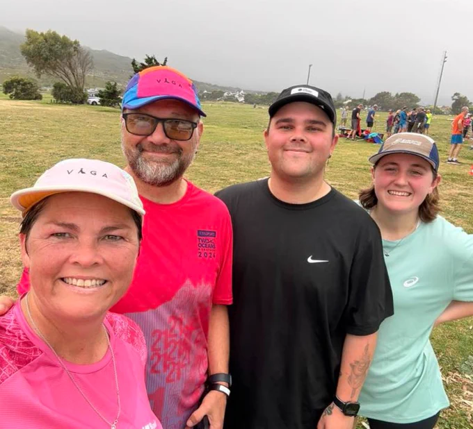 Four parkrunners smiling for a selfie in a field.