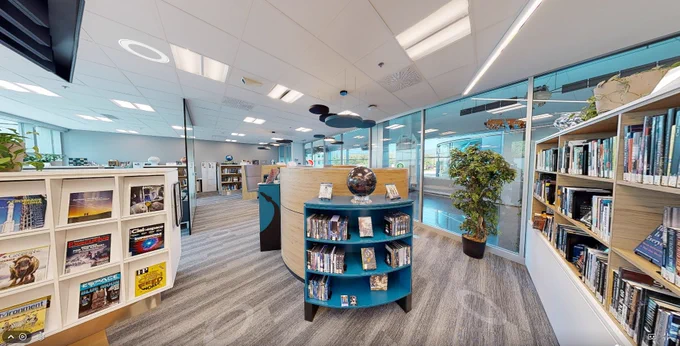 Interior view of the Larkin Kerwin Library at the Canadian Space Agency headquarters. The image shows modern shelves filled with books and magazines about space and science