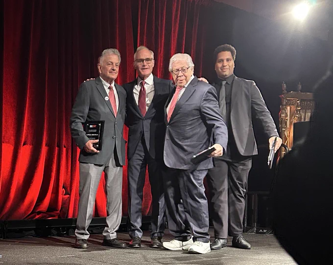 Four men on stage at Gotham Hall.
