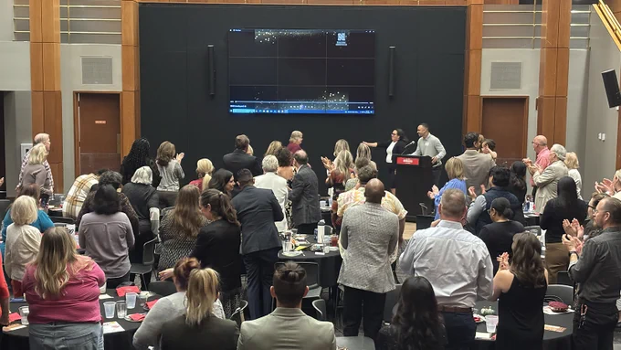 crowd gives a standing ovation for Cindy DeRyke as she is recognized for 35 years of service at the University of Nebraska-Lincoln as she prepares to retire in January 2026
