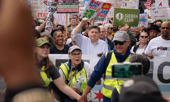 Governor Pritzker raises his fist in protest.