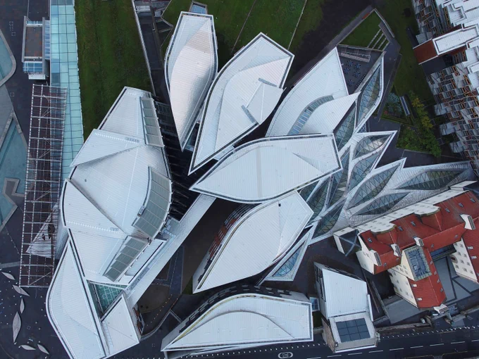 View of the Scottish parliament building from above, clearly showing the boat shared committee towers and the scattered leaves shapes of the garden Lobby skylights.