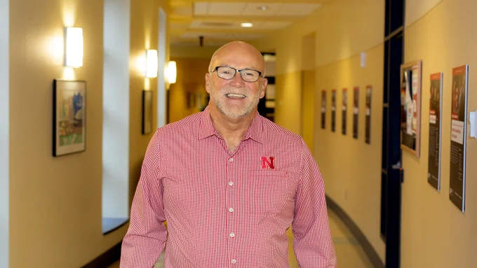 Don Johnson smiles in the hallway of Teachers College Hall at the University of Nebraska-Lincoln