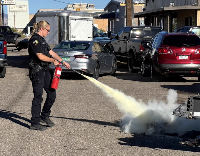 officer using extinguisher to put out fire