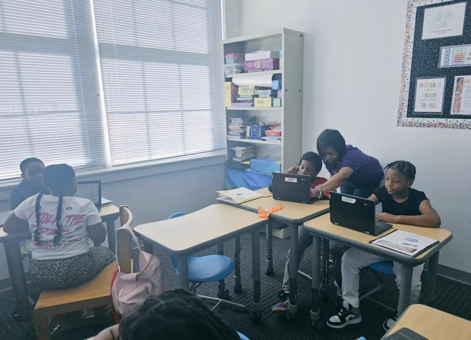 Scholars designing their statues and Dr. Hillian (standing) guiding scholar as he designs his statute