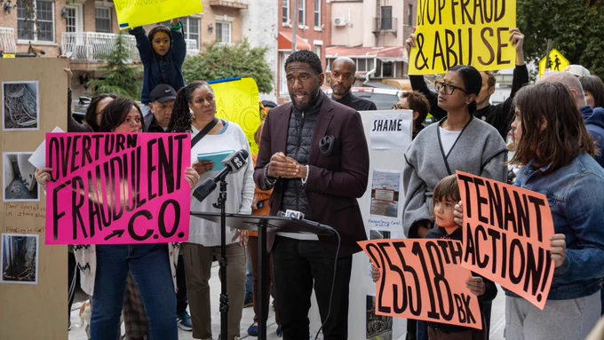 The Public Advocate speaks outside of the building with tenants who hold signs reading "Overturn fraudulent certificate of occupancy" and "Tenant Action!"