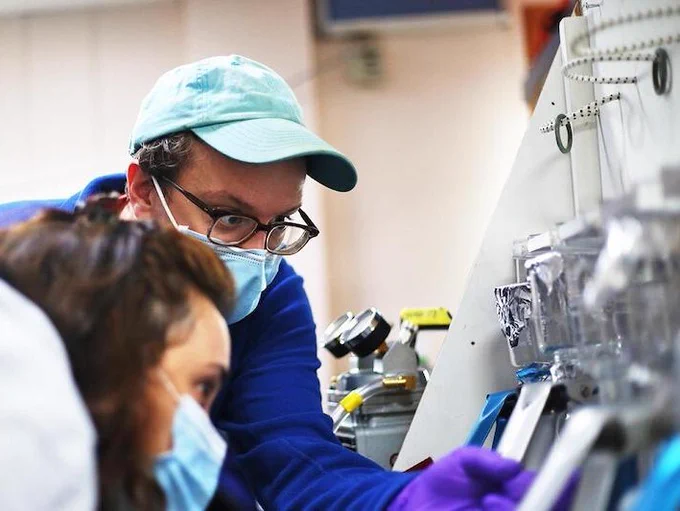 Henry and his colleague check for leaks in glass towers used to filter carbon samples aboard the RV Sarmiento de Gamboa (North Atlantic 2021). Photo by Marley Parker. 