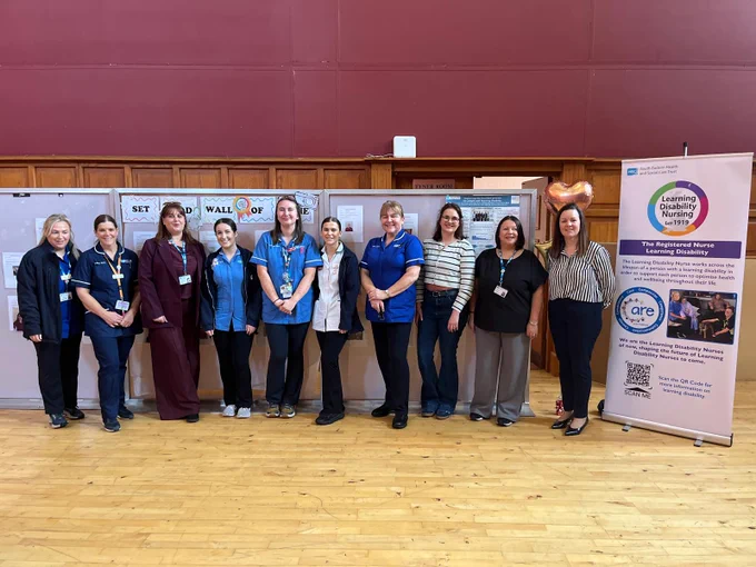Group of healthcare professionals standing in front of informational banners at a health event.