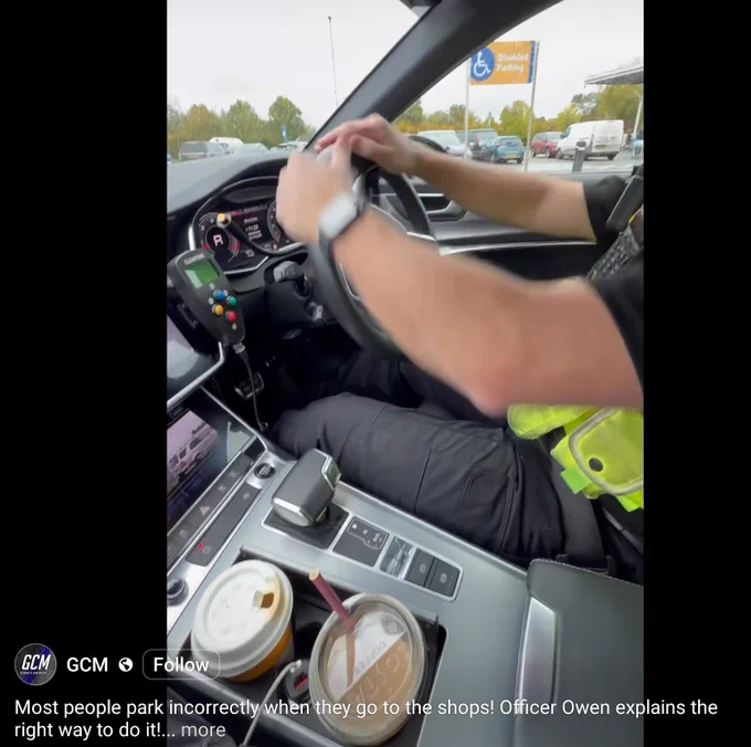 A screenshot of gcm from Facebook reversing a police car when in a Tesco's car park, the image shows a McDonald's coffee cup and a Costa cup with straw in the holders.