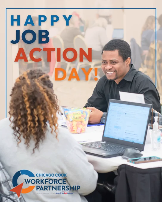 A young black man smiling as he is being interviewed for a job at a career event. The text, "Happy Job Action Day!," is also overlayed on the top left corner.