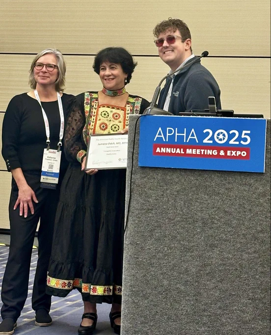A group of people smile and stand at award ceremony