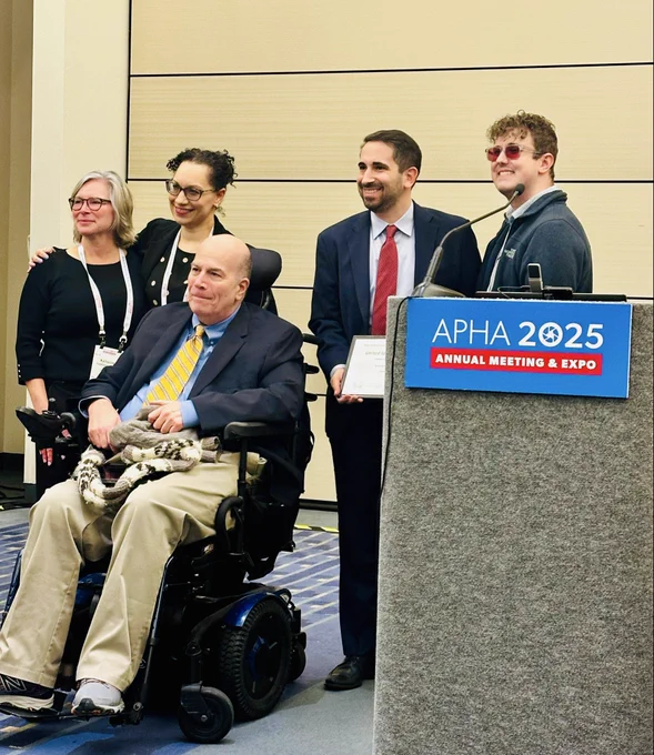 A group of people smile with award
