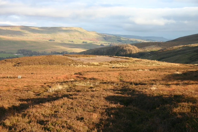 Landscape view of hills with shadows being cast in the foreground. 
