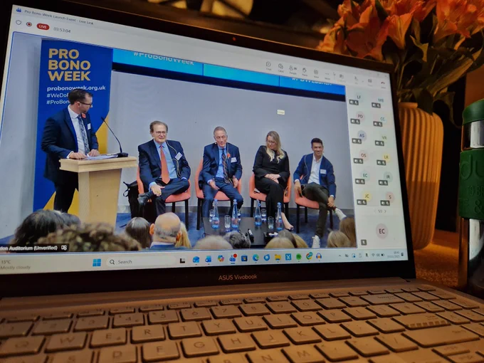 Emma's laptop screen shows the live stream of the UK PBW launch event from London.