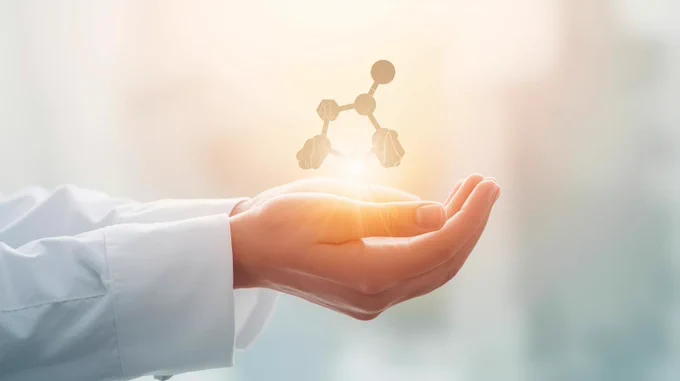 Scientist holding a chemical compound image bathed in light