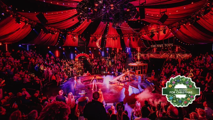 An audience watching Come Alive! The Greatest Showman Circus Spectacular inside a circus tent.
