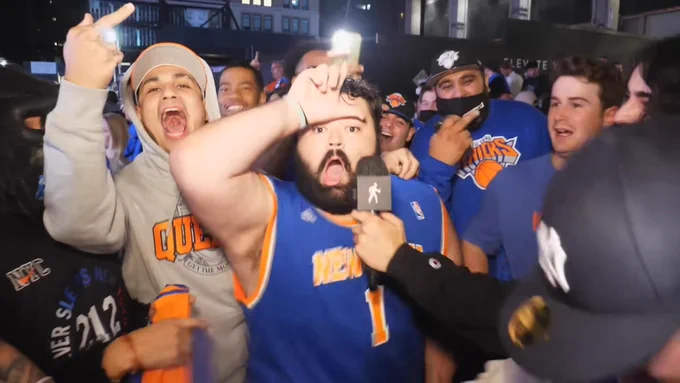Photo of a New York Knicks fan holding an L to his forehead.