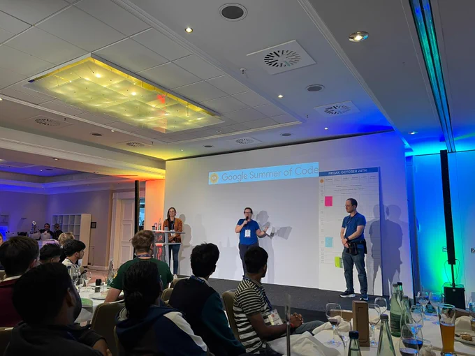 Three Mentor Summit organizers on stage introducing the event