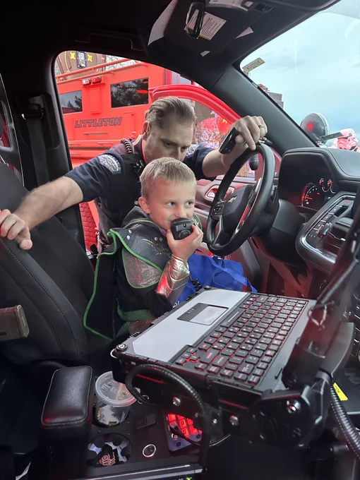 A kid in a Police Car is using the police radio