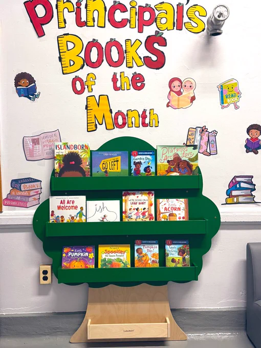 Photo of a bookshelf holding children's books, with the sign "Principals Books of the Month."