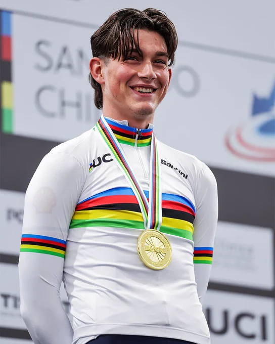 Josh Tarling smiles on the podium as he recieves his gold medal and rainbow jersey 