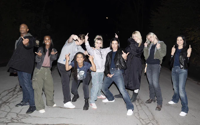 The cast of Gen V and The Boys on set of the Gen V finale. From left to right, Jessie T Usher, Keeya King, Asa Germann, Jaz Sinclair, Lizze Broadway, Derek Luh, Maddie Phillips, Erin Moriarty, and London Thor. They’re all giving us a middle finger.