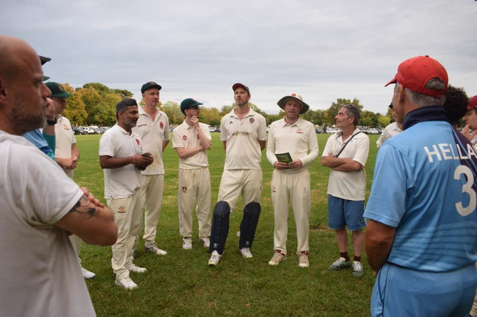 Team huddle with Bushmen skipper Harry holding a copy of the history of the club to hand to Corfu's captain Alex
