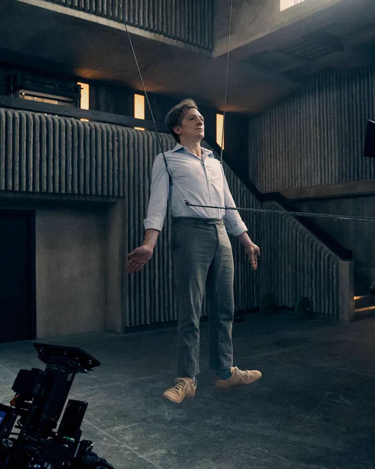 Behind the scenes photo from Gen V of Ethan Slater as Thomas Godolkin floating in the air with wires
