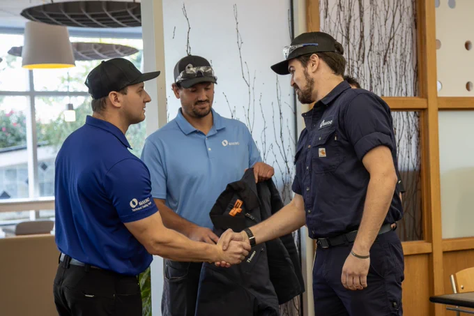 A graduate of Makino's 17-week PQS Training program being congratulated by Makino team members. 