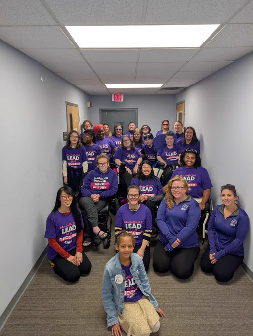 A large group of disabled women and girls wearing purple tshirts that say "When disabled girls lead, we all succeed"