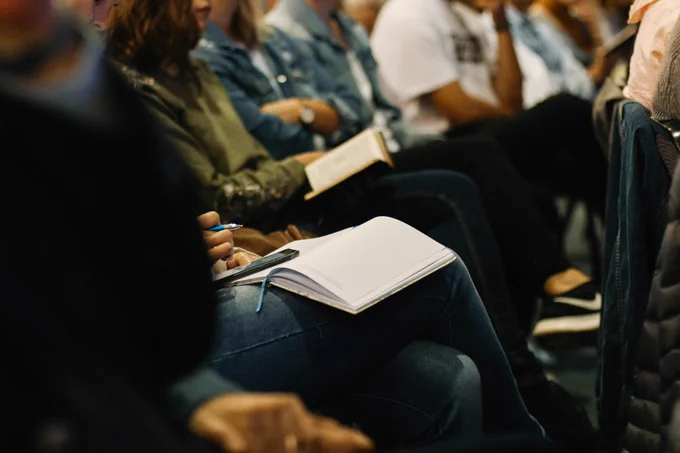 People with notebooks at a conference