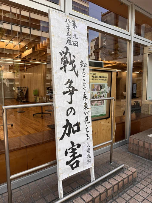 第9回パネル展　知ることで未来が見える　戦争の加害

入り口に立てられた看板、白地に筆で書かれている。入場無料とも書かれている。