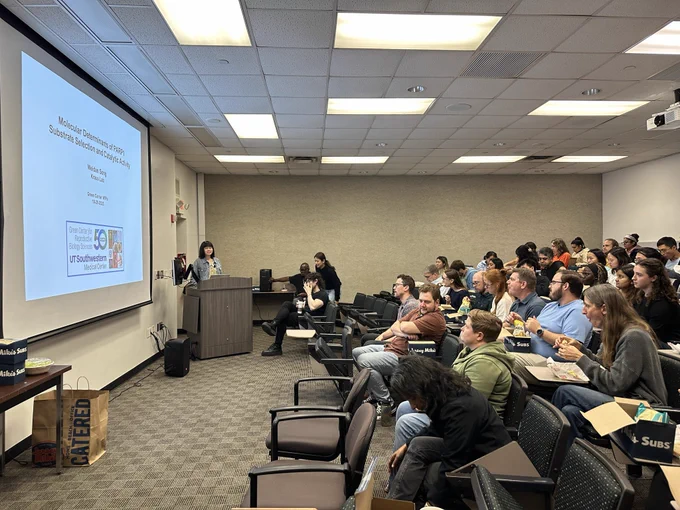 Weidan Song presenting her research to a full classroom