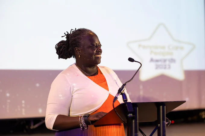 Evelyn smiling as she gives a speech on stage at the Pennine Care People Awards