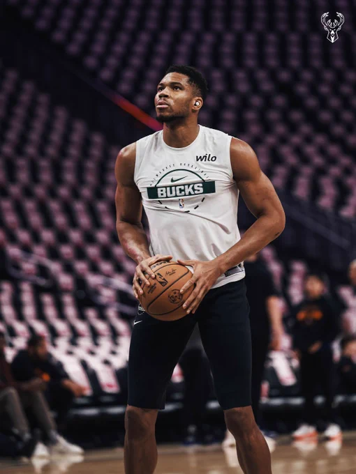 A photo of Giannis holding the ball on the court preparing to shoot pregame at Fiserv Forum.