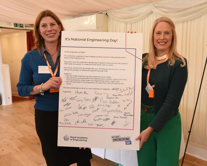 Two individuals holding up the Engineers 2030 pledge board at a parliamentary event on National Engineering Day.