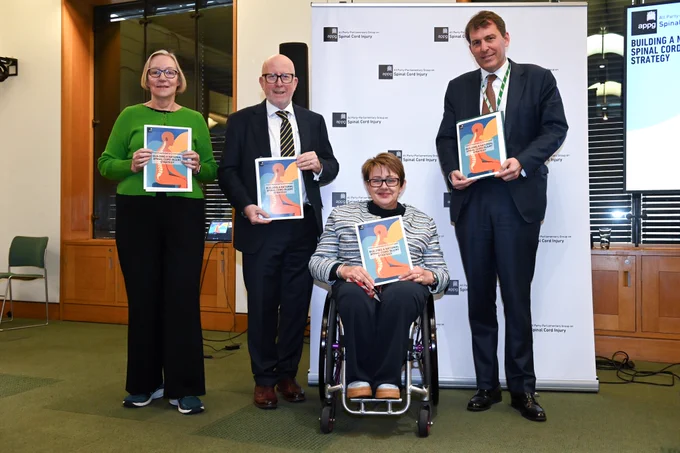 A group of Parliamentarians at the All-Party Parliamentary Group on Spinal Cord Injury report launch. Gill Furniss, Andy McDonald, Baroness Grey-Thompson, and John Glen are each holding a copy of the report.