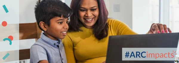 Mother and child looking at a laptop screen together. #ARCimpacts logo