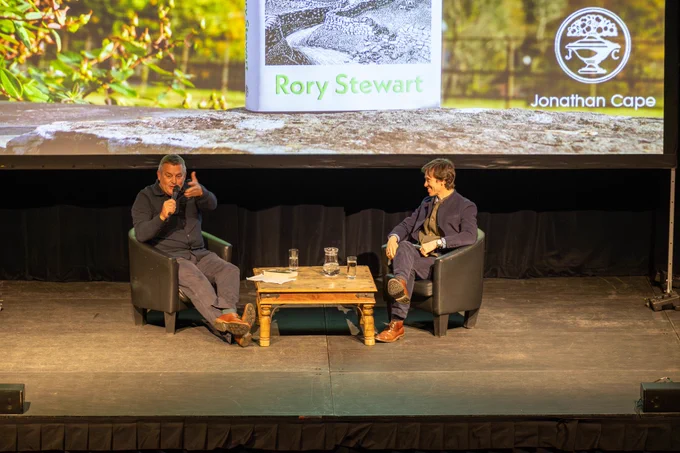 james reaching out to crowd and rory smiling at him as he speaks 