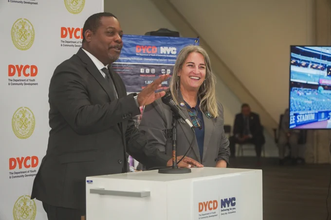 Commissioner Keith Howard and Susan Haskel are speaking at a podium. 