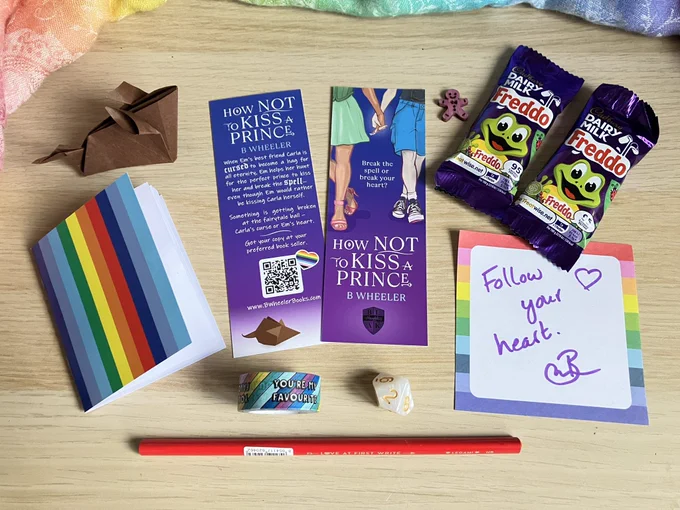 Prize giveaway bundles includes 2 x How NOT To Kiss A Prince bookmarks, 2 x Freddos, origami rat, signed bookplate, mini notebook, heart-shaped pencil, washi tape, D10 die, tiny wooden gingerbread man