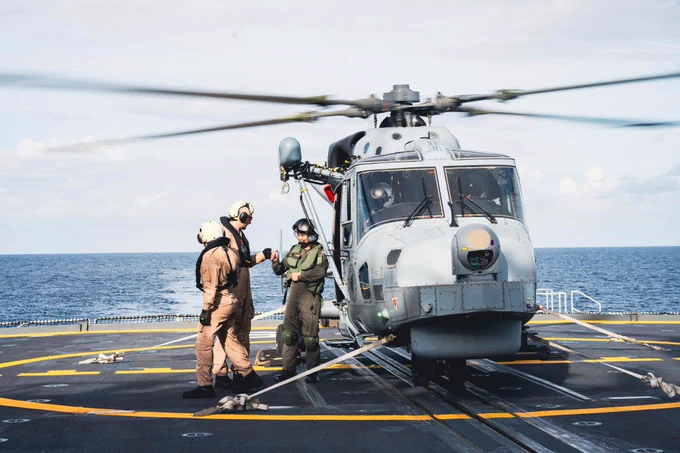 Sailor 1st Class Yianni Giannisi of His Majesty's Canadian Ship MAX BERNAYS fist bumps a member of the Philippine Navy with Helicopter AW159 Wildcat on the flight deck for Helo Operations as part of Exercise SAMA SAMA during Operation HORIZON at sea on 10 October 2025. 

Photo Credit: Sailor 1st Class Jordan Schilstra, Canadian Armed Forces Photo
