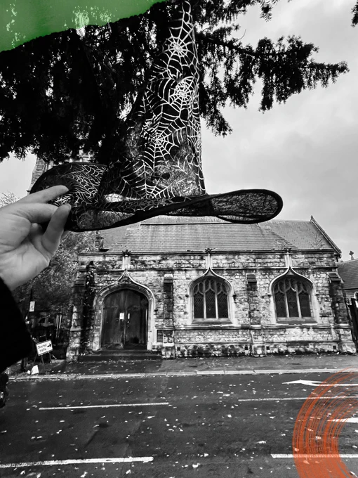 Streatham substation, photographed in black and white. A witches hat is held up in the photo, and green and orange elements have been added to the picture.