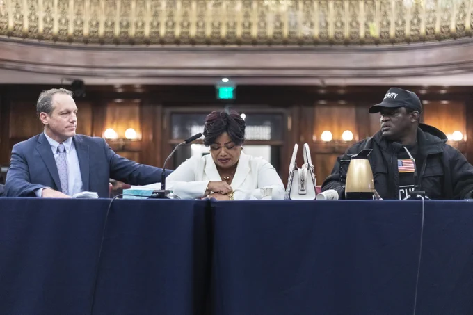 32BJ SEIU president Manny Pastreich comforts Aland Etienne's wife as she cries giving a testimony at a Committee on Consumer and Worker Protection hearing in Council Chambers.